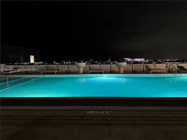 view of pool at twilight