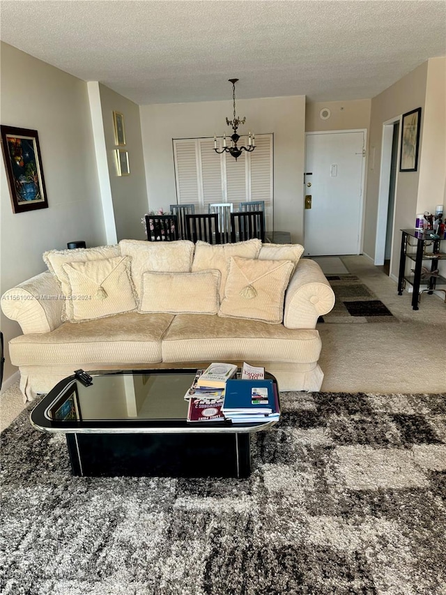 living room featuring a textured ceiling, a chandelier, and carpet