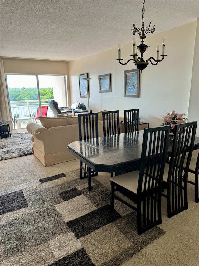 carpeted dining area featuring a notable chandelier and a textured ceiling