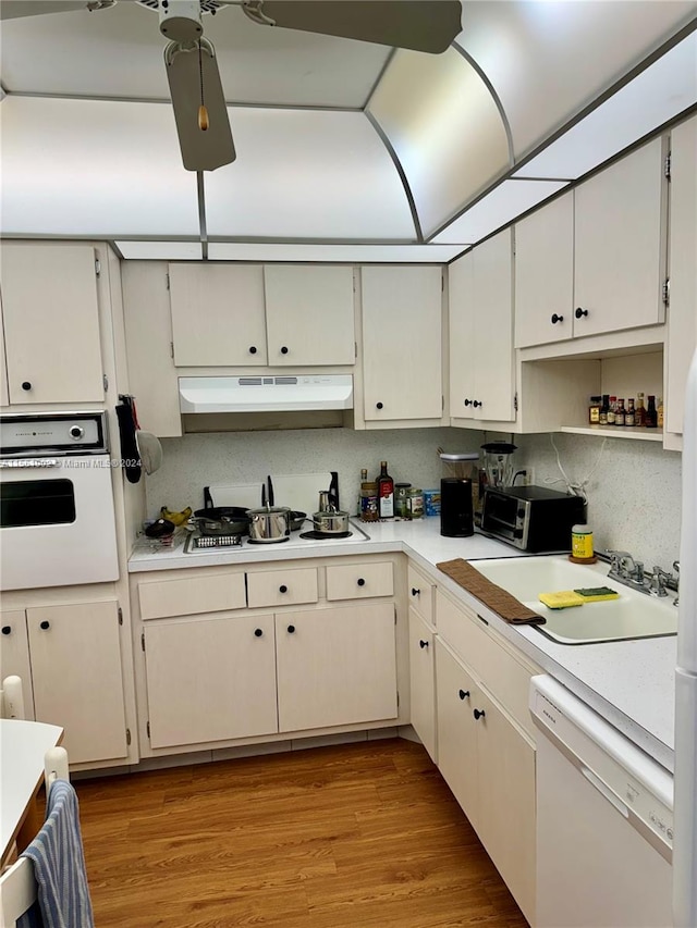 kitchen with oven, dishwasher, ceiling fan, and light hardwood / wood-style flooring