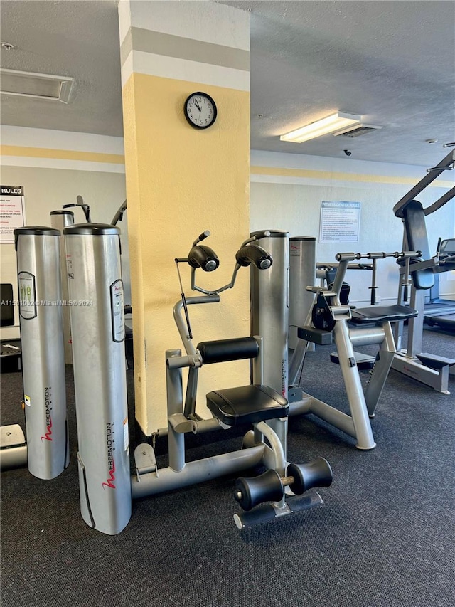 exercise room featuring a textured ceiling and electric water heater