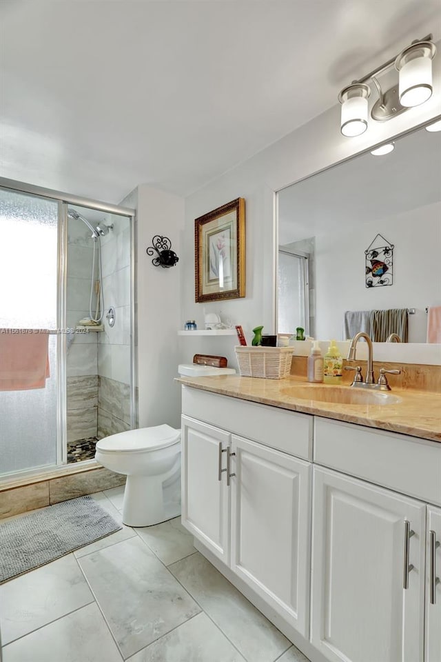 bathroom featuring vanity, tile flooring, a shower with shower door, and toilet