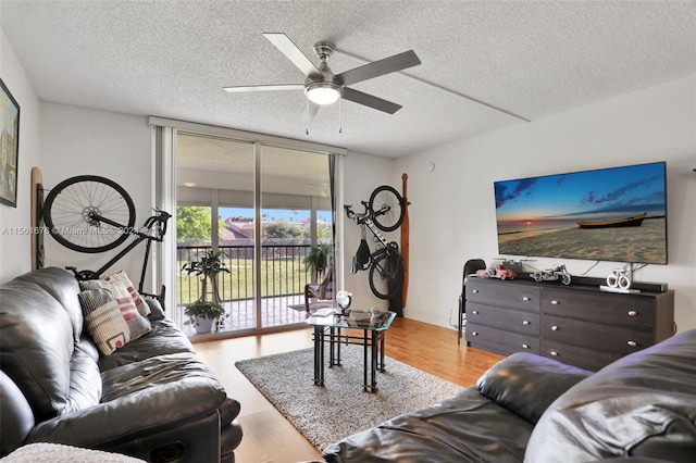 living room featuring expansive windows, a textured ceiling, ceiling fan, and light hardwood / wood-style flooring