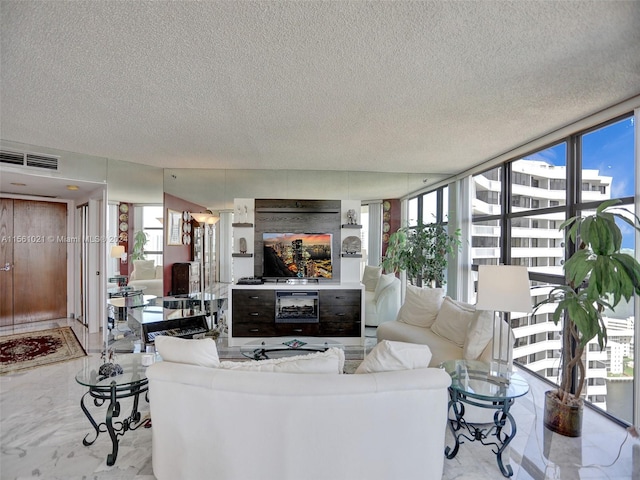 tiled living room with a textured ceiling and a wall of windows