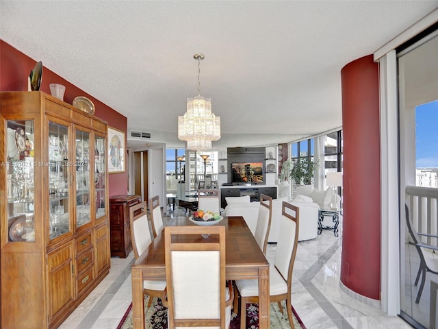 dining room with light tile flooring, a notable chandelier, a textured ceiling, and a wealth of natural light