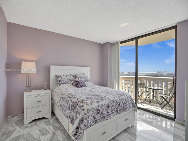 bedroom featuring access to exterior, a textured ceiling, light tile flooring, and expansive windows