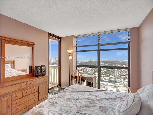 bedroom with a wall of windows and a textured ceiling