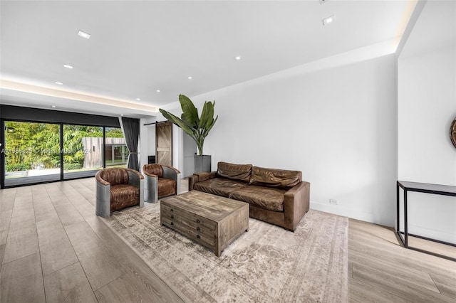 living room with recessed lighting, a barn door, and wood finished floors