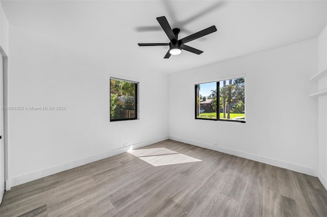 unfurnished room featuring a ceiling fan, wood finished floors, and baseboards