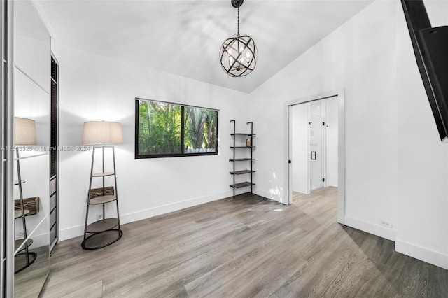 interior space featuring light hardwood / wood-style flooring, lofted ceiling, and a chandelier