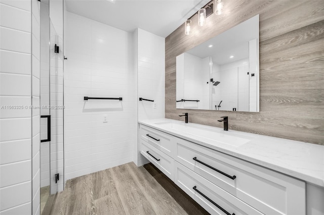 bathroom with a shower with shower door, vanity, and hardwood / wood-style floors