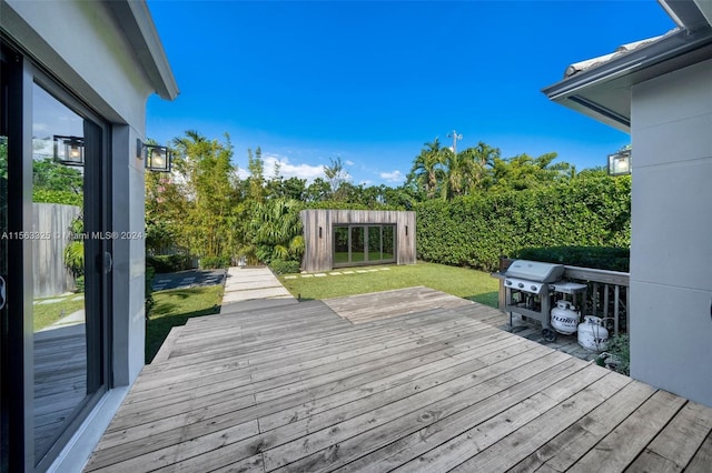 deck with grilling area and a lawn