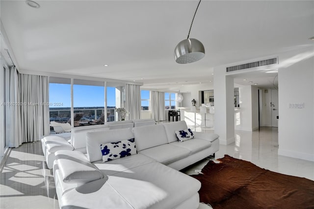 tiled living room featuring floor to ceiling windows