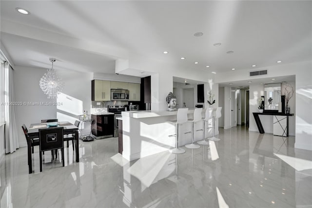 kitchen with a breakfast bar area, a notable chandelier, and stainless steel appliances