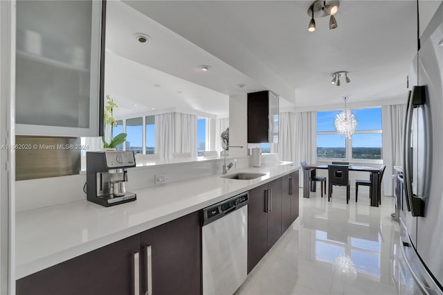 kitchen with dark brown cabinets, appliances with stainless steel finishes, plenty of natural light, and sink