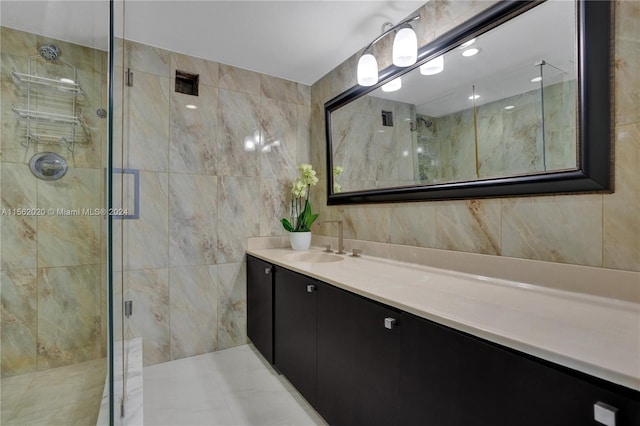 bathroom with tile walls, vanity, and a shower with shower door