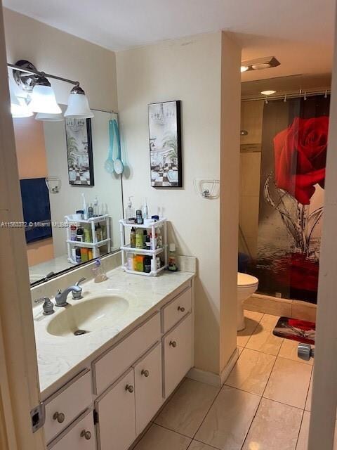 bathroom with tile flooring, large vanity, and toilet