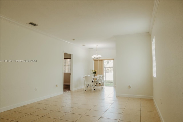 spare room featuring a chandelier, ornamental molding, and light tile floors