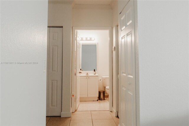 corridor with light tile floors and sink