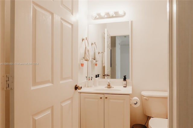 bathroom featuring toilet and vanity with extensive cabinet space