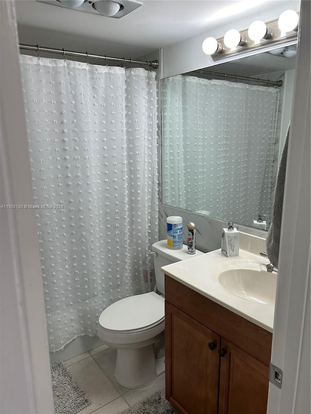 bathroom featuring toilet, tile floors, and vanity