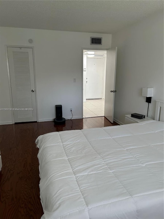 bedroom featuring a textured ceiling and light wood-type flooring