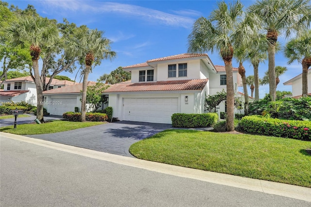 mediterranean / spanish-style house with a garage and a front lawn