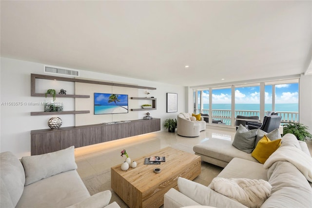 tiled living room with floor to ceiling windows and a water view