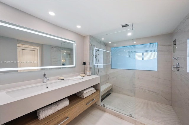 bathroom with a shower with door and vanity