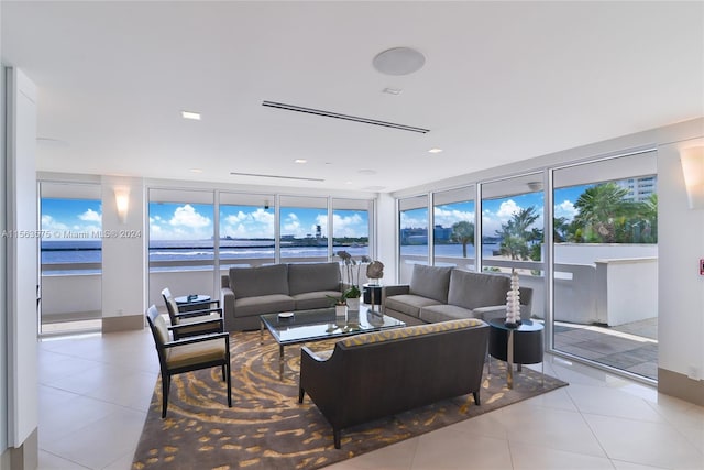 living room with plenty of natural light, light tile flooring, and a water view