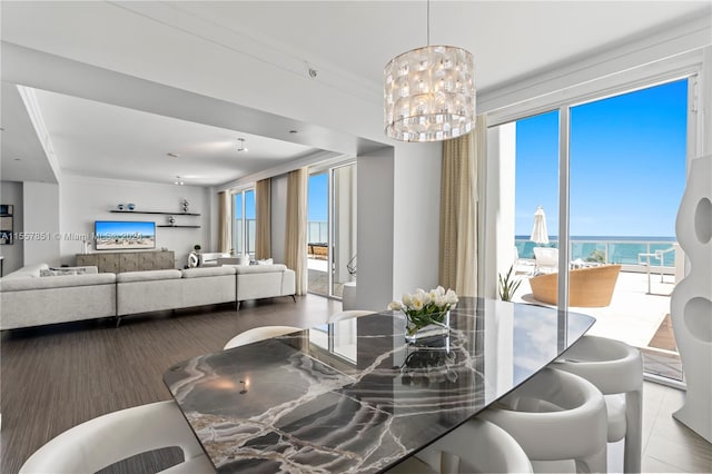 dining room with ornamental molding, a notable chandelier, and a water view