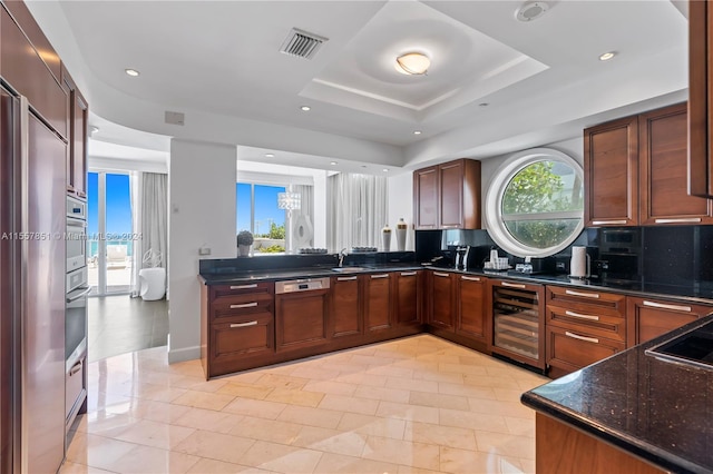 kitchen with sink, backsplash, wine cooler, a raised ceiling, and light tile floors