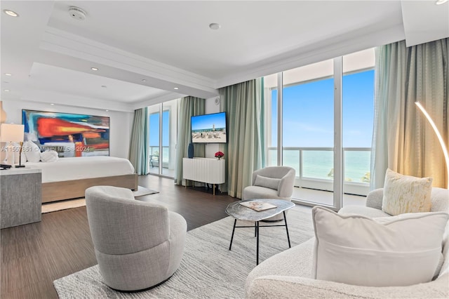 living room featuring dark wood-type flooring, expansive windows, and a water view