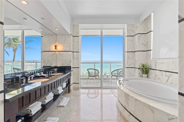 bathroom with tile flooring, a water view, vanity, and tile walls