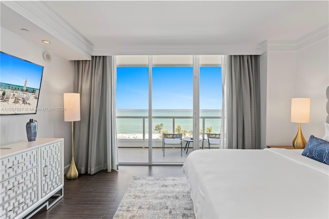 bedroom with a water view and dark hardwood / wood-style flooring