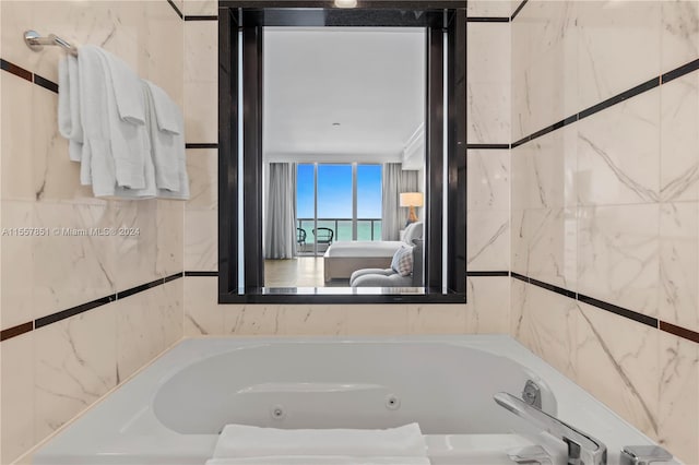 bathroom featuring a washtub and tile walls