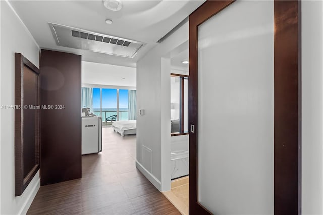 hallway featuring floor to ceiling windows and tile floors