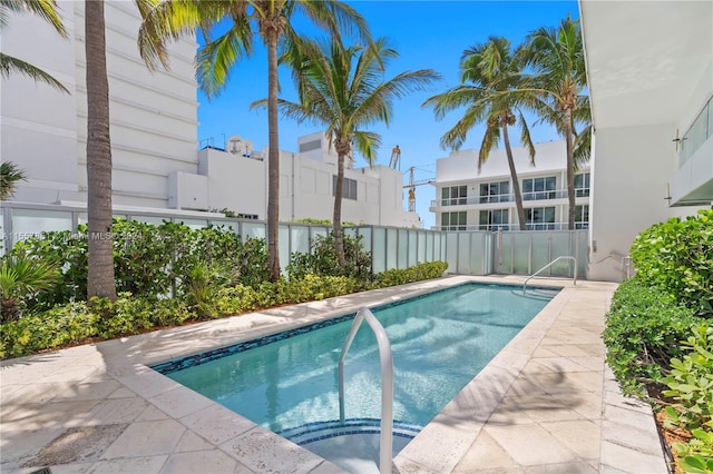 view of swimming pool with a hot tub