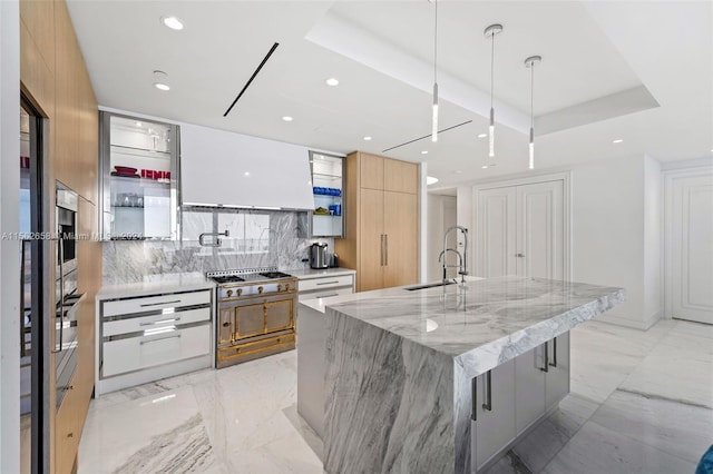 kitchen with light stone countertops, a center island with sink, tasteful backsplash, and light tile flooring