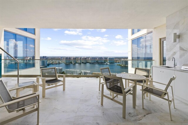 balcony featuring a water view and sink