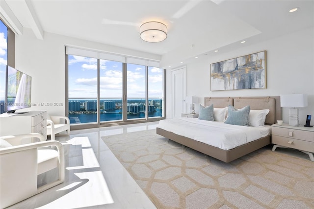 bedroom with a water view, expansive windows, and recessed lighting