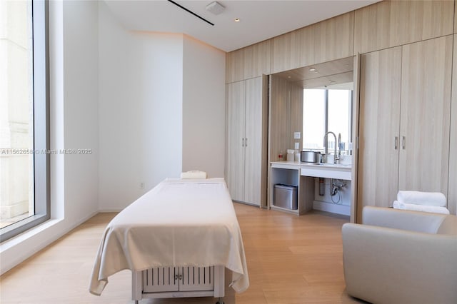 bedroom featuring light wood-type flooring and a sink