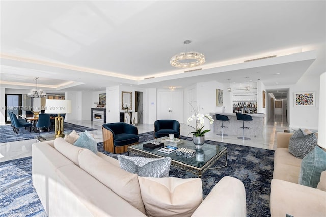 living room with a chandelier and a raised ceiling