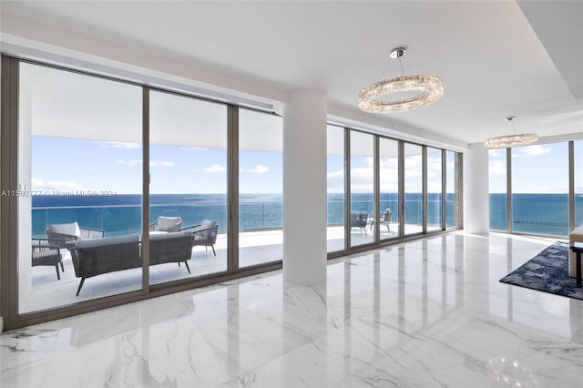 interior space featuring a water view, a wall of windows, and a view of the beach