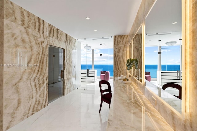 hallway with a water view and floor to ceiling windows