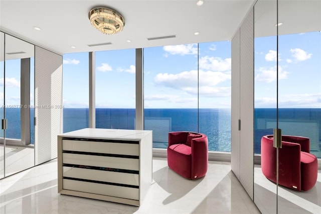 bedroom featuring expansive windows, multiple windows, and a water view