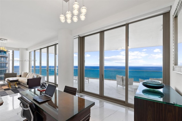 interior space featuring a wealth of natural light, a water view, and a chandelier