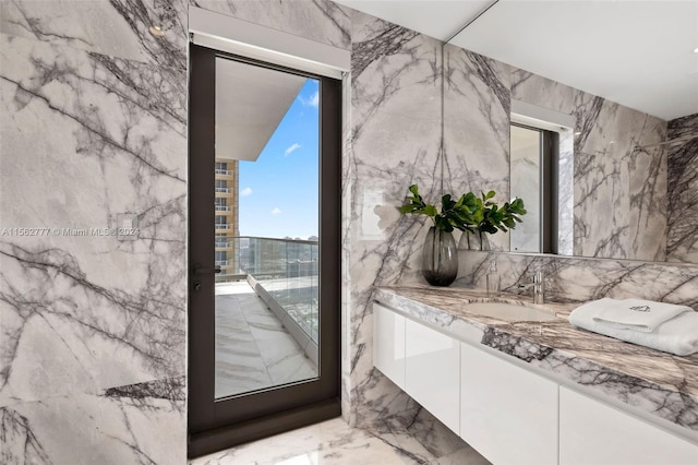 bathroom featuring vanity and tile walls