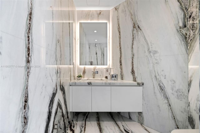 bathroom with vanity and tile walls