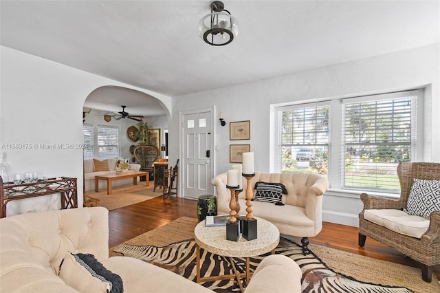 living room with ceiling fan with notable chandelier and dark wood-type flooring